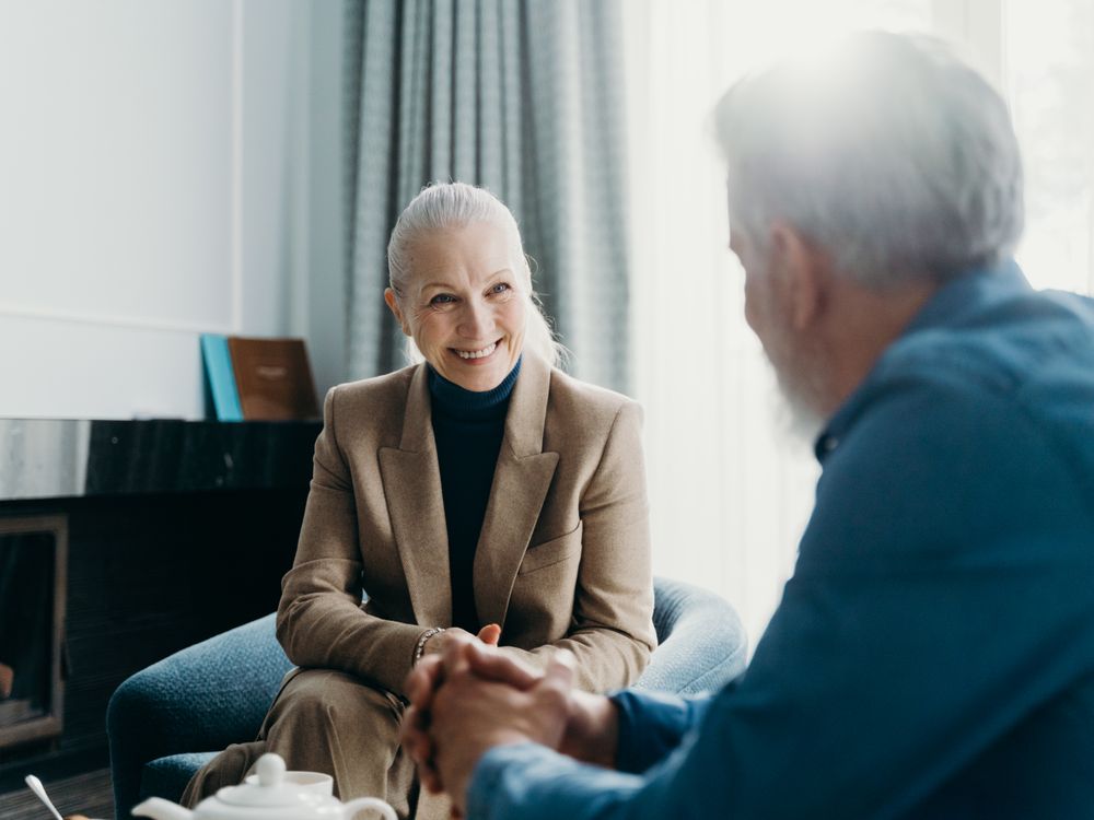 A senior smiling warmly during a friendly in-home wellness visit